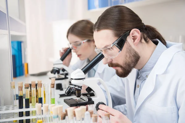 Científicos trabajando con microscopios — Foto de Stock