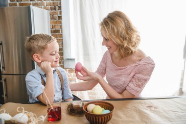 Mother and son painting Easter eggs clipart