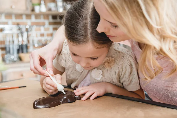 Mutter und Tochter basteln Schokohasen — Stockfoto