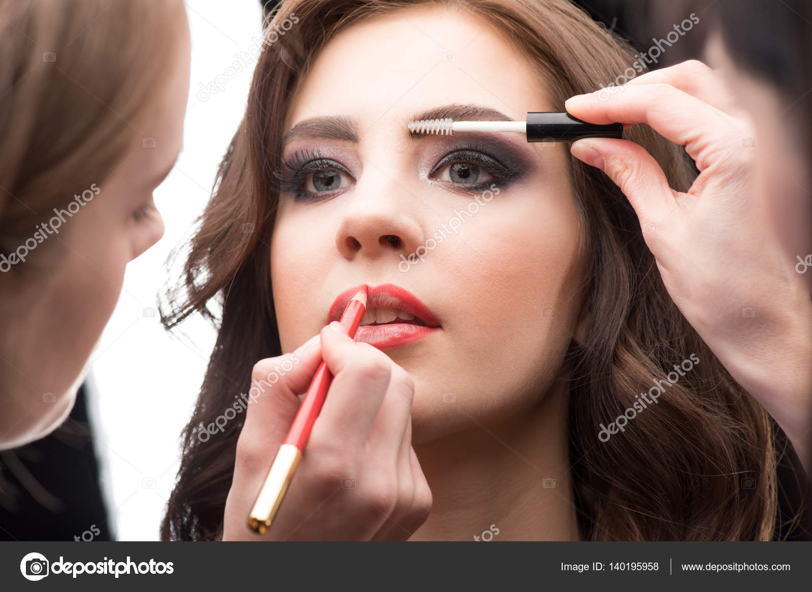 Woman applying makeup Stock Photo by ©DmitryPoch 140195958