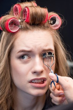Makeup artist correcting eyelashes  clipart