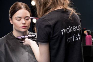 Make-up artist applying eyeshadow clipart