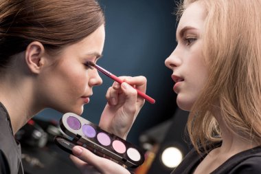 Make-up artist applying eyeshadow clipart