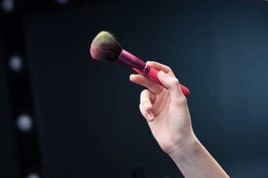 Make-up brush in hand clipart