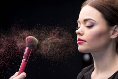 Make-up artist sprinkling face of model clipart
