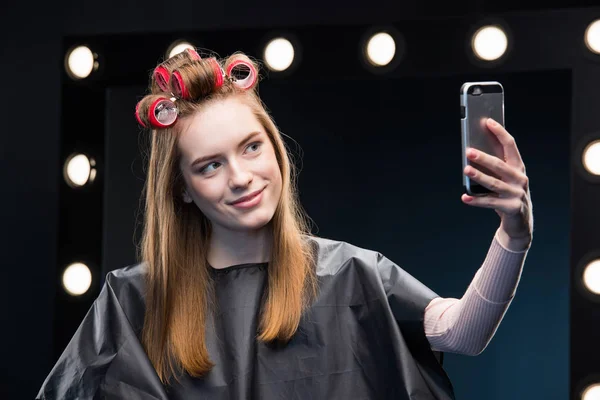 Woman in curlers taking selfie — Stock Photo, Image