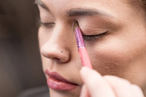 Maquillador aplicando sombra de ojos — Foto de Stock