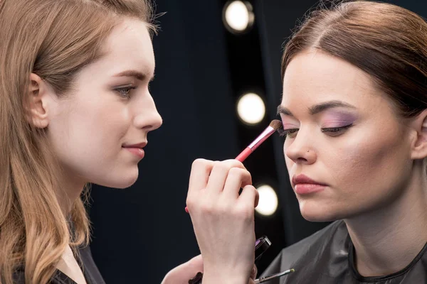 Maquillador aplicando sombra de ojos — Foto de Stock