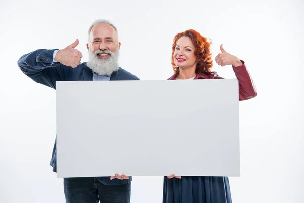 Pareja sosteniendo tarjeta en blanco — Foto de Stock