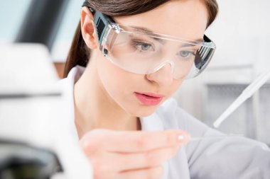 Female scientist in protective glasses  clipart