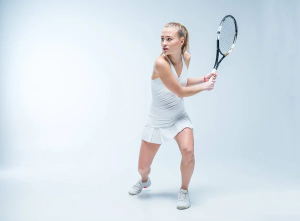 Jonge vrouw spelen tennis — Stockfoto