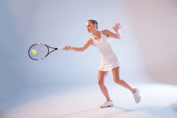 Jonge vrouw spelen tennis — Stockfoto