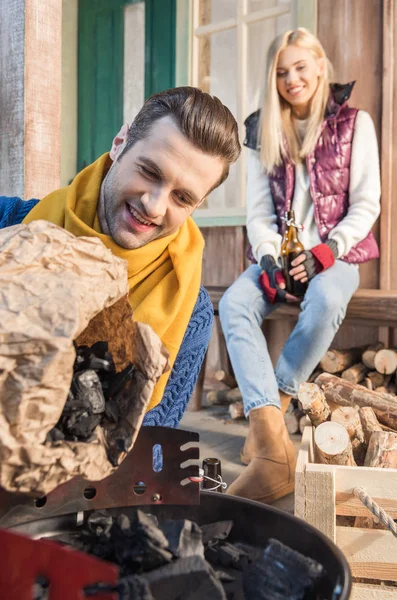 Mann füllt Grill mit Holzkohle — kostenloses Stockfoto