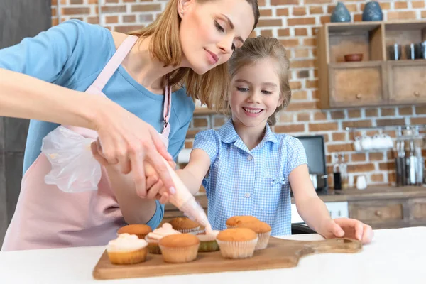 Moeder en dochter bakken cupcakes — Stockfoto