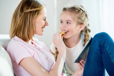 Mother and daughter with digital tablet clipart