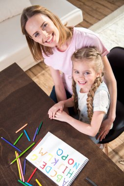 Mother and daughter learning alphabet clipart