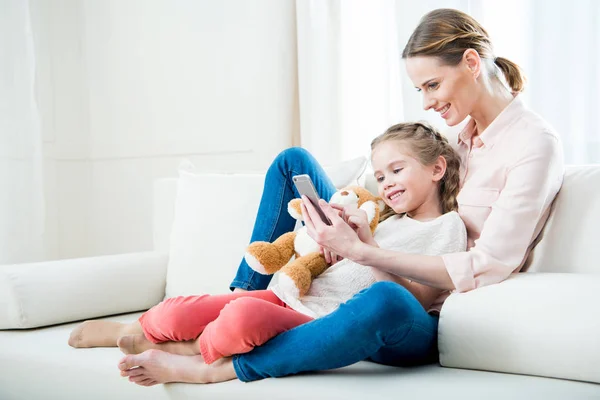 Moeder en dochter gebruikend smartphone — Stockfoto