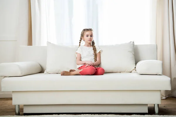 Κορίτσι που κάθεται στον καναπέ — Φωτογραφία Αρχείου