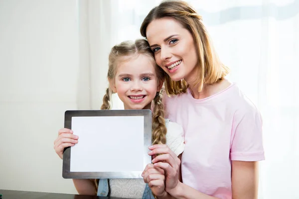 Mãe e filha mostrando tablet digital — Fotografia de Stock