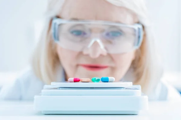 Científico senior mirando píldoras — Foto de Stock