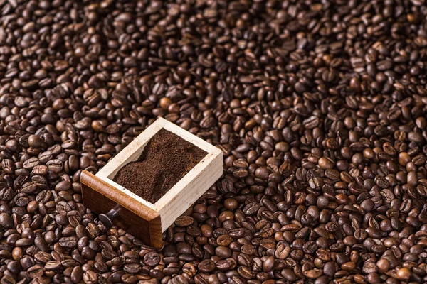 Ground coffee on coffee beans — Stock Photo, Image