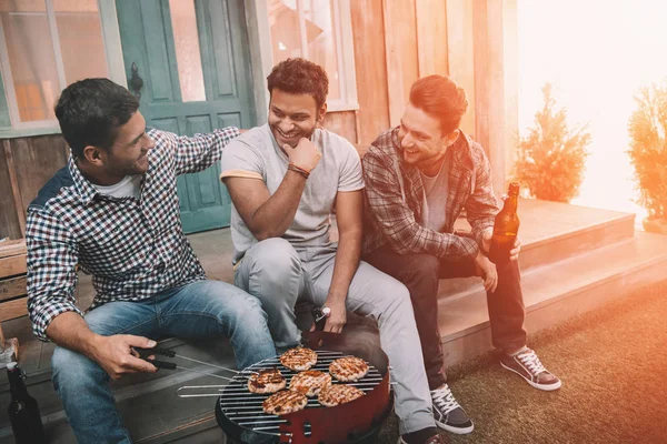 Vrienden drinken bier en het maken van de barbecue — Stockfoto