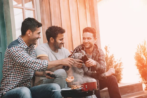 Vänner dricka öl och att göra grill — Stockfoto