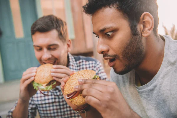 Uomini che mangiano hamburger — Foto Stock