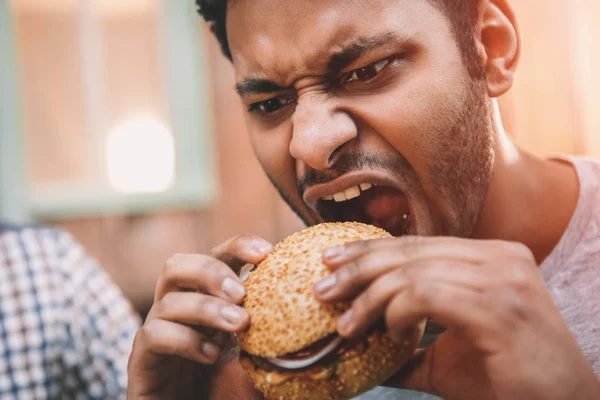 Člověk jíst hamburger — Stock fotografie