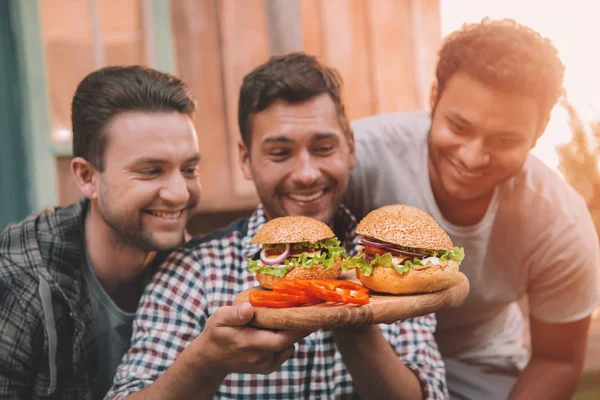 Hombres comiendo hamburguesas — Foto de Stock