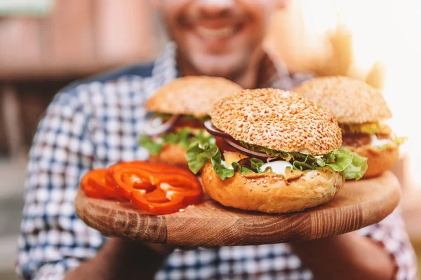 Mann hält Hamburger in der Hand — Stockfoto