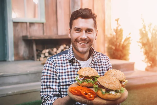 Muž hospodářství hamburgery — Stock fotografie