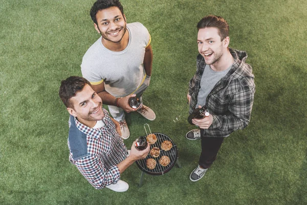 Friends drinking beer and making barbecue — Stock Photo, Image