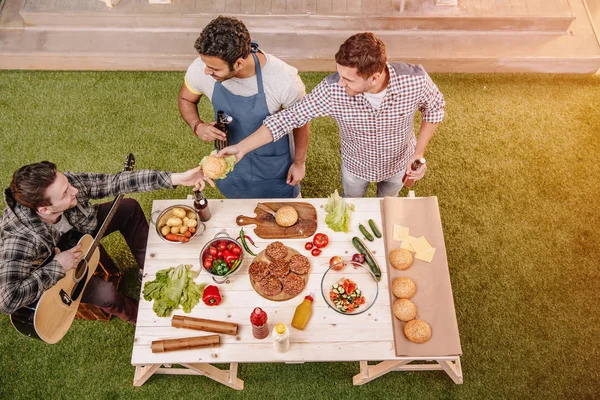 Venner som lager hamburgere – stockfoto