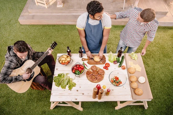 Venner som lager hamburgere – stockfoto