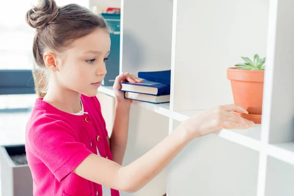 Menina Escolhendo livro — Fotografia de Stock