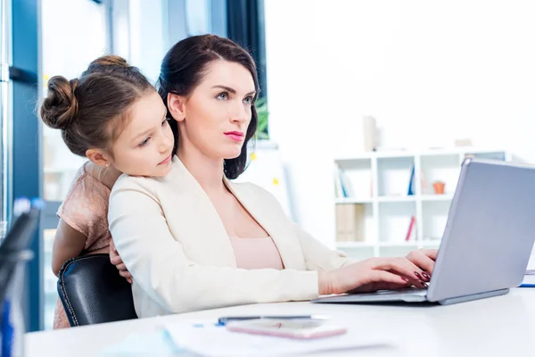Business woman working with daughter — стоковое фото