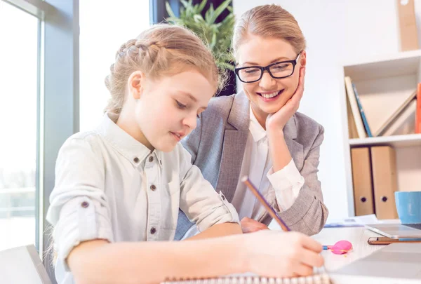 Filha desenho com a mãe no escritório — Fotografia de Stock