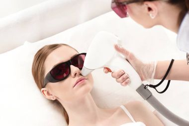 woman receiving laser skin care clipart