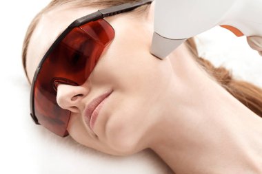 Woman receiving laser treatment  clipart