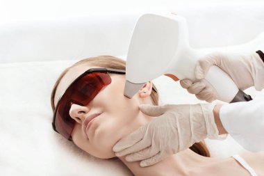 Woman receiving laser treatment  clipart
