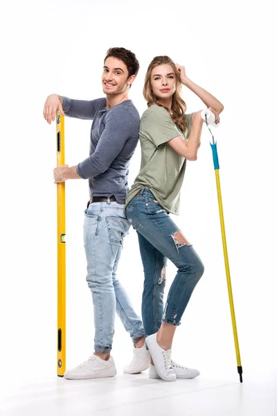 Pareja con rodillo de pintura y nivel — Foto de Stock