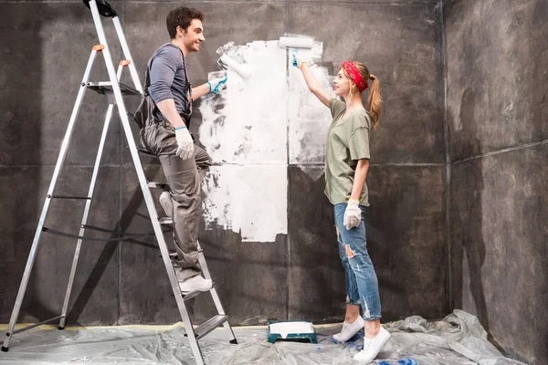 Couple painting wall