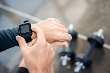 man using  smartwatch at gym clipart