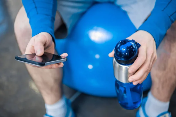 Homem usando smartphone no ginásio — Fotografia de Stock