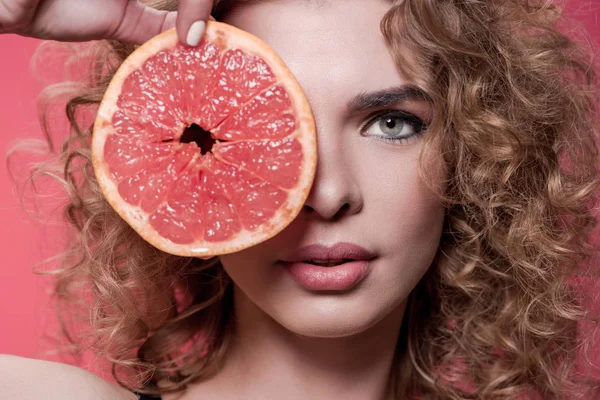 Woman holding piece of grapefruit — Stock Photo, Image