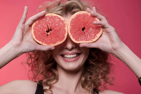 Mulher segurando pedaços de toranja — Fotografia de Stock