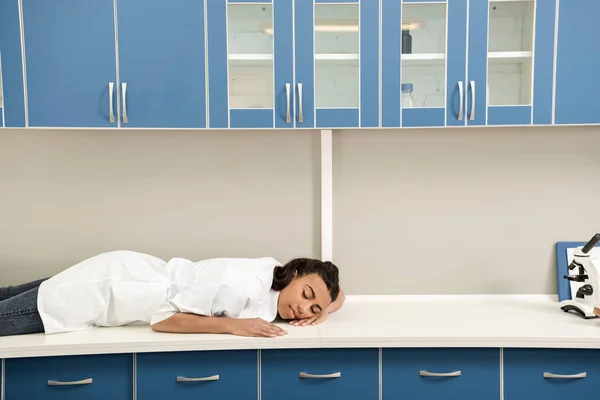 Cientista menina dormindo na mesa em laboratório — Fotografia de Stock