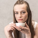 Ung kvinna dricker kaffe