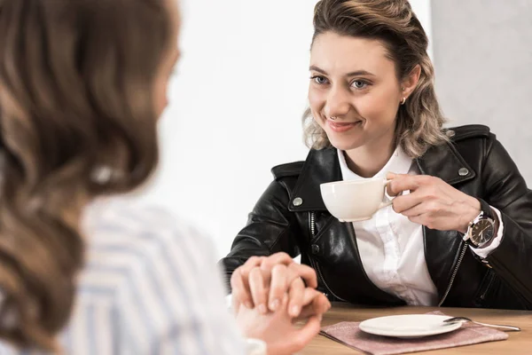 Novias cogidas de la mano mientras bebe café — Foto de stock gratis